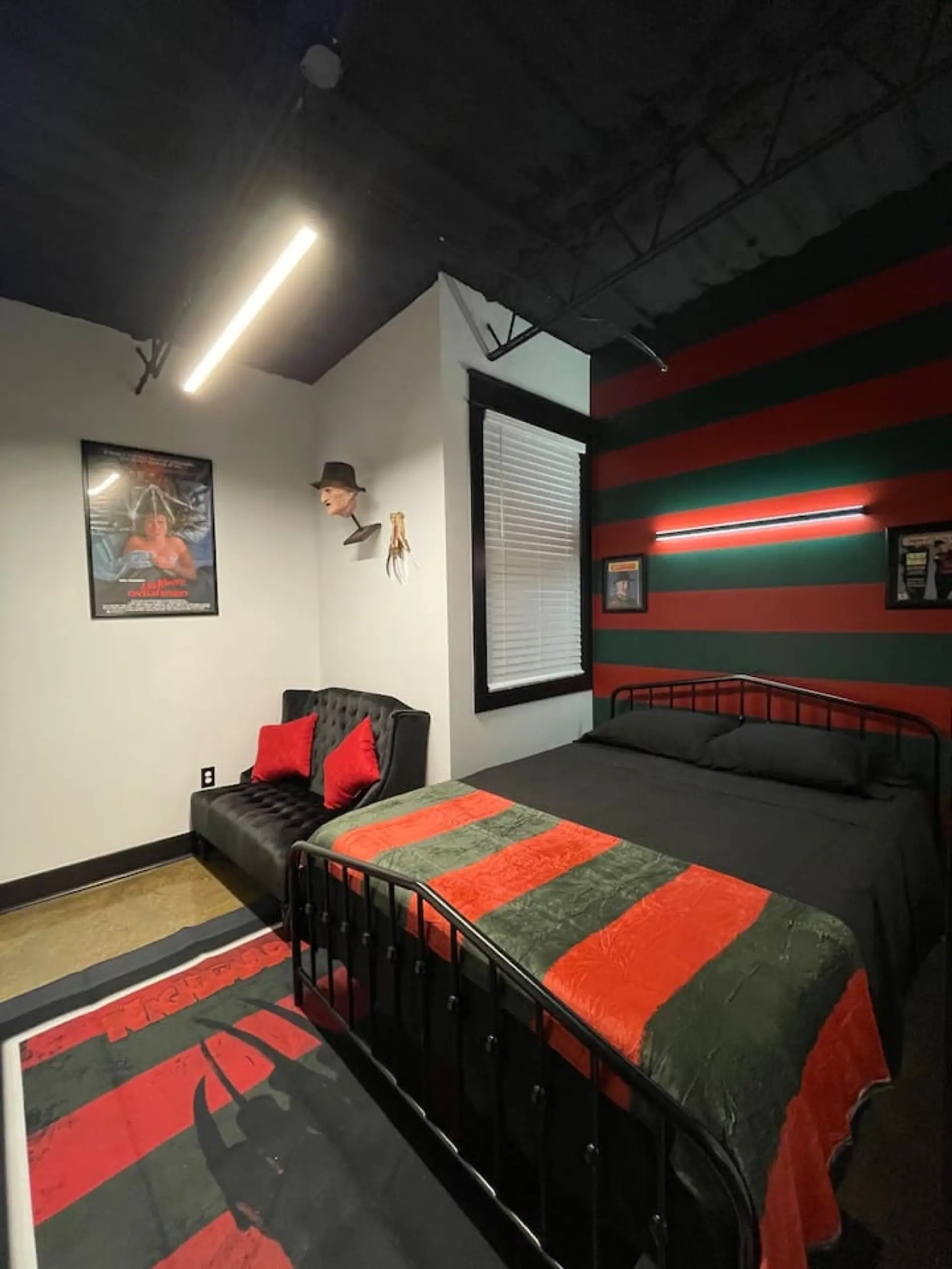 Freddy Krueger themed master bedroom with red and green striped wall, queen bed, and Nightmare on Elm Street decor