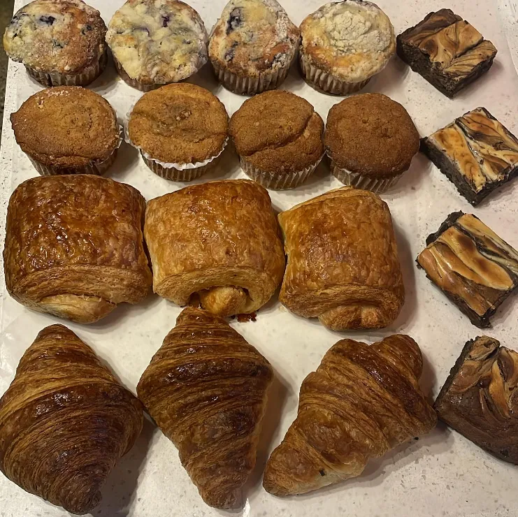 A tray of fresh-baked pastries at Black House Café, muffins, croissants, pain au chocolat, and brownies